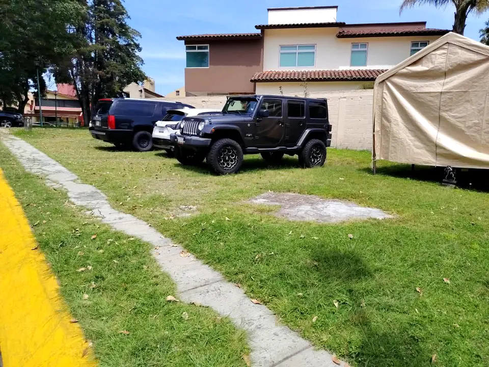 El andador de concreto que cruza el pasto del terreno junto a la guarnición